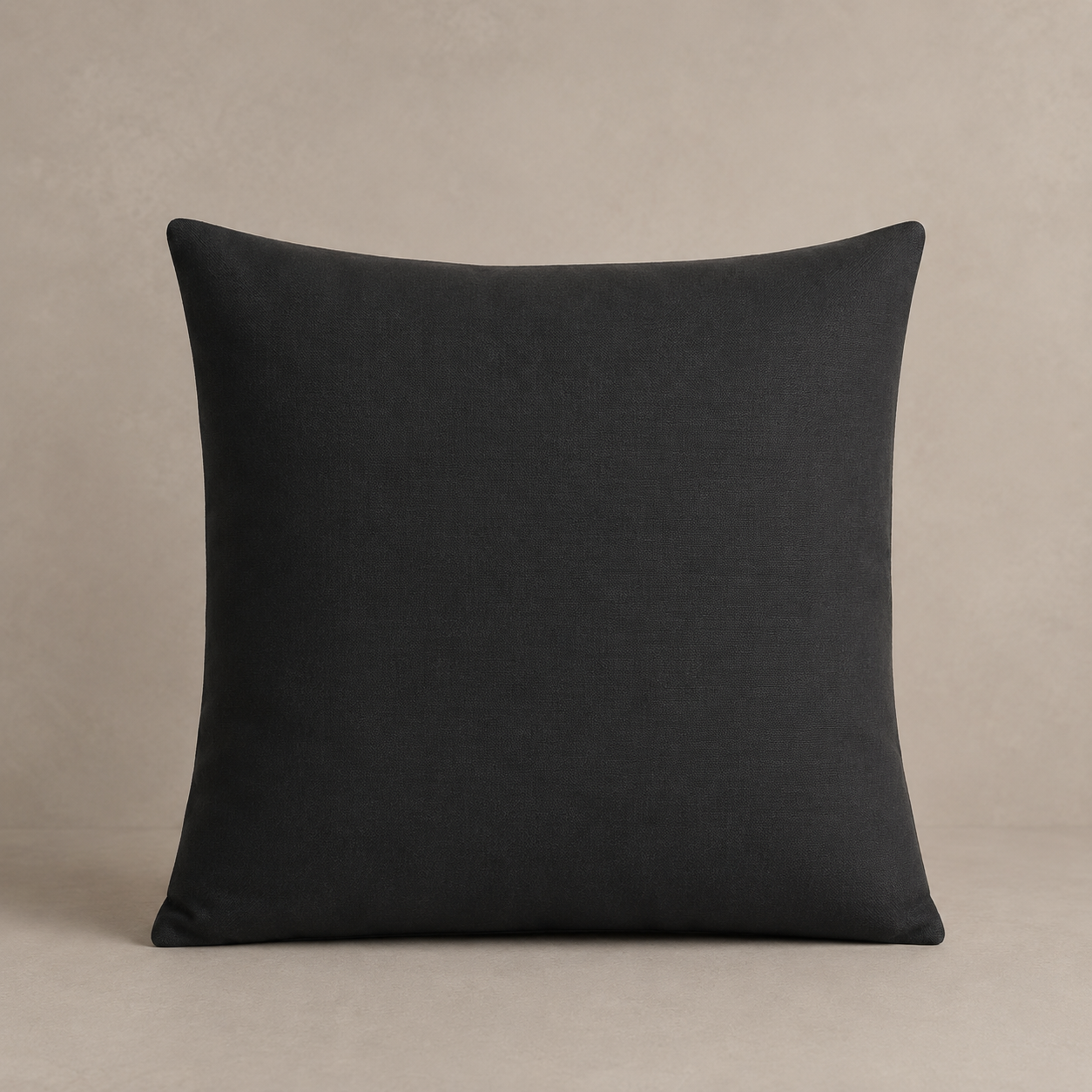 Charcoal grey pillow on a beige background