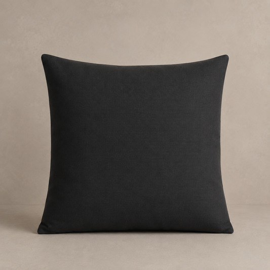 Charcoal grey pillow on a beige background