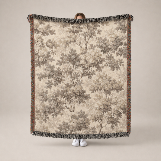 Person holding a large tree-patterned blanket with a neutral background