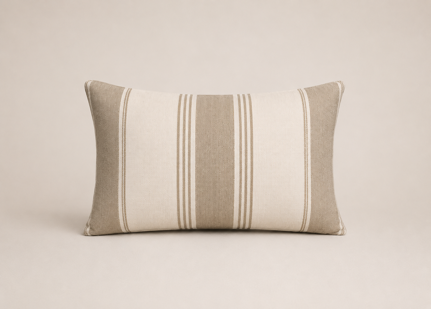 Striped pillow with beige and brown tones on a beige background