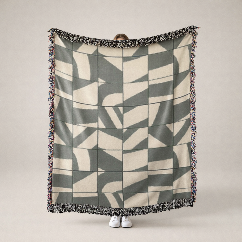 Person holding a geometric patterned blanket with a neutral background