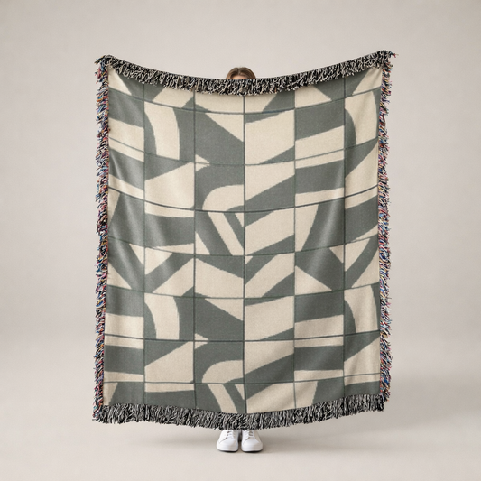 Person holding a geometric patterned blanket with a neutral background